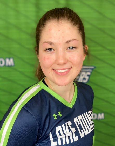 Natalie Lother in her softball uniform, smiling at the camera.