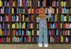 A drawing of a woman standing in front of a bookshelf, reaching for a book
